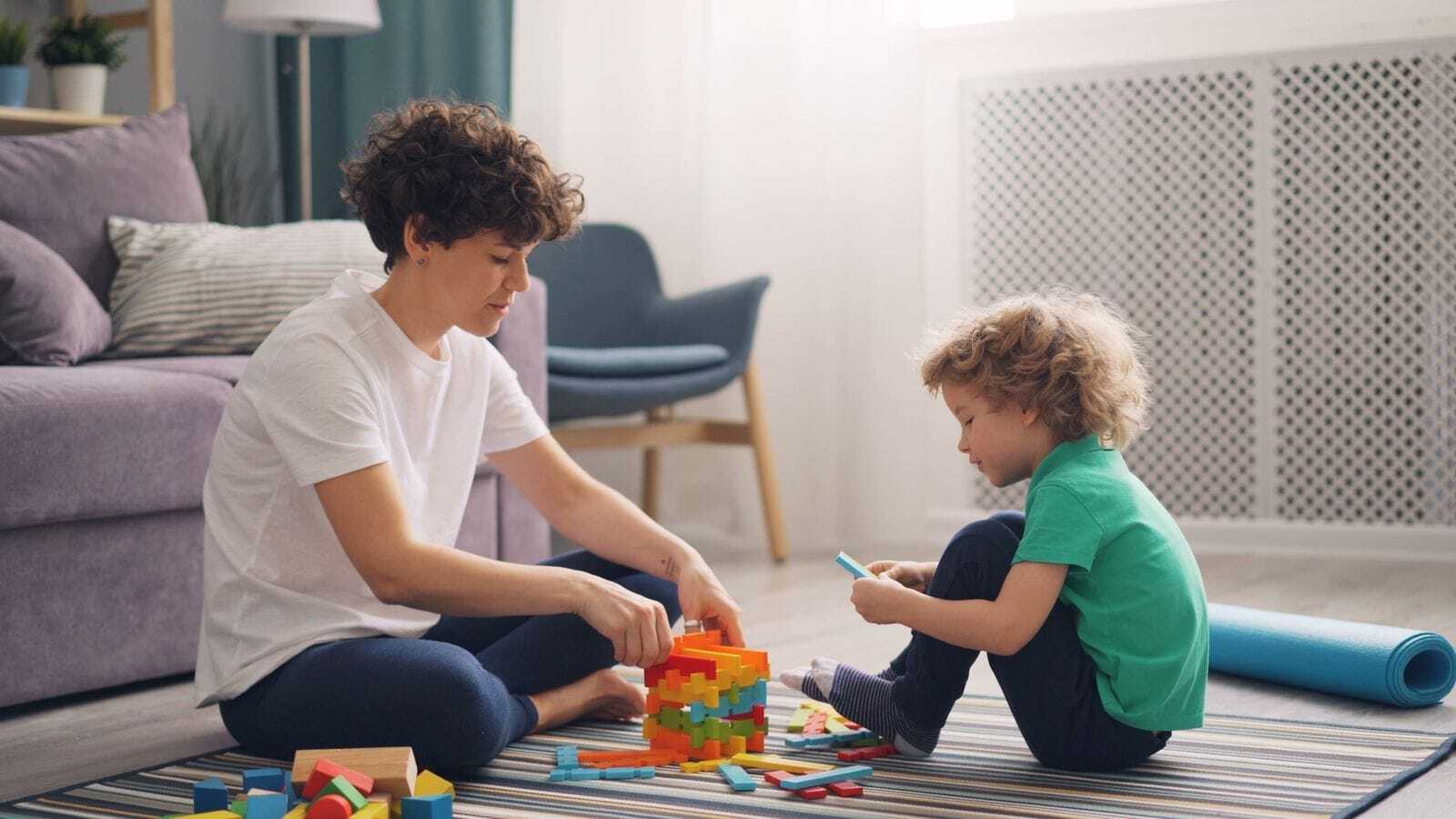 Professional nanny playing with a child in a bright living room reflecting a strong long-term nanny match